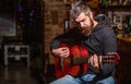 Live music. Guitars and strings. Bearded man playing guitar, holding an acoustic guitar in his hands. Music concept Royalty Free Stock Photo