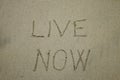 Live now, mindfulness concept, text written on the sand Royalty Free Stock Photo