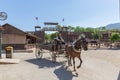 Live performance view of cowboy scenes, with a cowboy driving a cart with a horse, on Oasys - Mini Hollywood Western theme park,