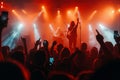 Live rock concert with band members in silhouette playing on stage, audience with hands up and smartphone recording