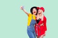 Live or Selfie time! Portrait of beautiful stilysh hipster best friends in fashionable clothes hugging with love, laughing for