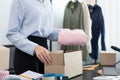 Live shopping concept a female dealer packing products into boxes after receiving orders from customers