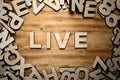 LIVE word made with block letters lying on wooden board