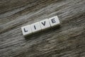 Live word made of square letter word on wooden background