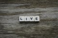 Live word made of square letter word on wooden background