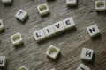 Live word made of square letter word on wooden background