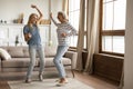 Elderly mother and millennial daughter dancing together in living room Royalty Free Stock Photo