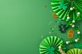 Top view snapshot: gold coins, dynamic fans, shamrocks, confetti, and beads necklace strewn on vibrant green surface