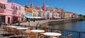 Lively coastal promenade with cafes, umbrellas, and bicycles for outdoor dining and leisurely fun