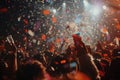 A lively crowd of people at a concert, joyfully celebrating as confetti fills the air, A burst of confetti rains down on the Royalty Free Stock Photo