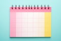 A lively image of a pink and yellow planner set against a vibrant bright blue background. Perfect for organization, crea Royalty Free Stock Photo