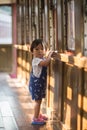 A lively little boy in blue overalls plays in a train car