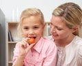 Lively little girl eating fruit with her mother Royalty Free Stock Photo