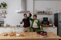 Lively middle-aged family couple dancing to disco music in the kitchen.Happy old man and woman having fun, entertaining together Royalty Free Stock Photo