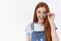 Lively surprised cute attractive redhead girl long natural red hair, touch glasses open mouth amazed, smiling broadly