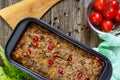 Liver casserole. Useful dish from the liver. Freshly baked pork liver souffle with rice and vegetables on a wooden table.