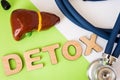 Liver detox concept photo. Word detox of volumetric letters is near 3D liver model and medical stethoscope. Medical diet program Royalty Free Stock Photo