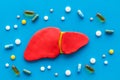 Liver diseases and treatment. Organ and pills on blue background top view