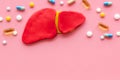 Liver diseases and treatment. Organ and pills on pink background top view copy space