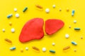 Liver diseases and treatment. Organ and pills on yellow background top view