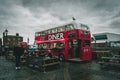 LIVERPOOL, ENGLAND, DECEMBER 27, 2018: People enjoying a meal on a cloudy day, beside a red double decker bus as food truck,