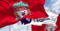 Liverpool Football Club and Premier League flags waving together on a clear day