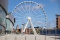 Ferris wheel in Kings Dock Liverpool, England on July 14, 2021. Four unidentified people