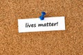 Lives matter. Text written on a piece of paper, cork board background