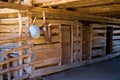 Animal stalls on an old log barn with harness and pail Royalty Free Stock Photo