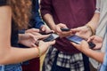 Living in a age of technology. a group of young unrecognizable people standing in a circle while browsing on their Royalty Free Stock Photo