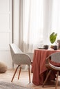 Living and dining room interior with grey couch and table covered with orange tablecloth