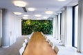 Living green wall, vertical garden indoors with flowers and plants under artificial lighting in meeting boardroom Royalty Free Stock Photo