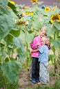 Living happy children brother and sister in the thickets of sunflower in the backyard of the farm