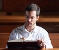 Living his life by way of the word. a young man reading the bible in church. Royalty Free Stock Photo