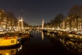 Houseboats reflecting in a canal in Amsterdam at night