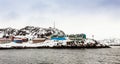 Living Inuit houses on the steep cliff covered in snow at the fjord, Maniitsoq town Greenland Royalty Free Stock Photo