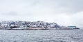 Living Inuit houses on the steep cliff covered in snow at the fjord, Maniitsoq Royalty Free Stock Photo