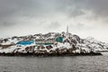 Living Inuit houses on the steep cliff covered in snow at the fjord, Maniitsoq town Greenland Royalty Free Stock Photo