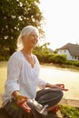 Living in the present. an attractive mature woman doing yoga in a beautiful garden setting. Royalty Free Stock Photo