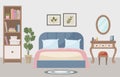 Warm and cozy bedroom with a comfortable bed, soft light lamp, dressing table, bookshelf and indoor plant. Interior concept. Royalty Free Stock Photo