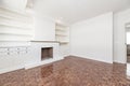 Living room in apartment with built-in fireplace, bright reddish parquet floors, halogen spotlights integrated into the ceiling