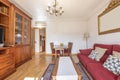 living room of an apartment furnished with a wooden bookcase with drawers, cabinets, a dining table with matching chairs and a Royalty Free Stock Photo