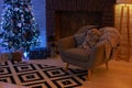 Living room with armchair and fireplace decorated for Xmas. Xmas room interior design, Christmas tree decorated with lights and ga Royalty Free Stock Photo