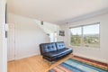 Living room with colorful carpet window overlooking forest city and water view