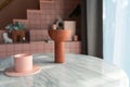 Living room corner decorated with clay ceramic vase and baby pink cup on white marble  table with pink tile stair in the Royalty Free Stock Photo