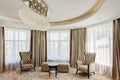 Living room with crystal chandelier in center of ceiling.