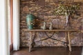 Living room with decorative table, stone wall behind.