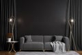 a living room with a gray couch and two lamps on either side of the couch and a black wall with a sign that says muck