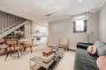 Living room with green velvet sofa, red cushions, mirrored