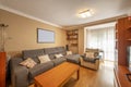 Living room of a house with a gray fabric sofa with chaise longue and cherry wood furniture